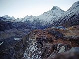 201 Annapurna Base Camp Before Sunrise - Annapurna III,  Gabelhorn, Machapuchare Annapurna Sanctuary Base Camp is a collection of stone huts surrounded by mountains and glaciers at around 4130m. This was the site of Chris Boningtons Base Camp for the 1970 British expedition that completed the first ascent of the Annapurna South Face. I was up early and walked in the -1C clear weather for ten minutes to the monument hill. Before the sun started rising, I looked back to the east of Annapurna Sanctuary Base Camp to see the ridge connecting Annapurna III (7555m) to Gandharva Chuli (Gabelhorn, 6248m) to Machapuchare (6993m).